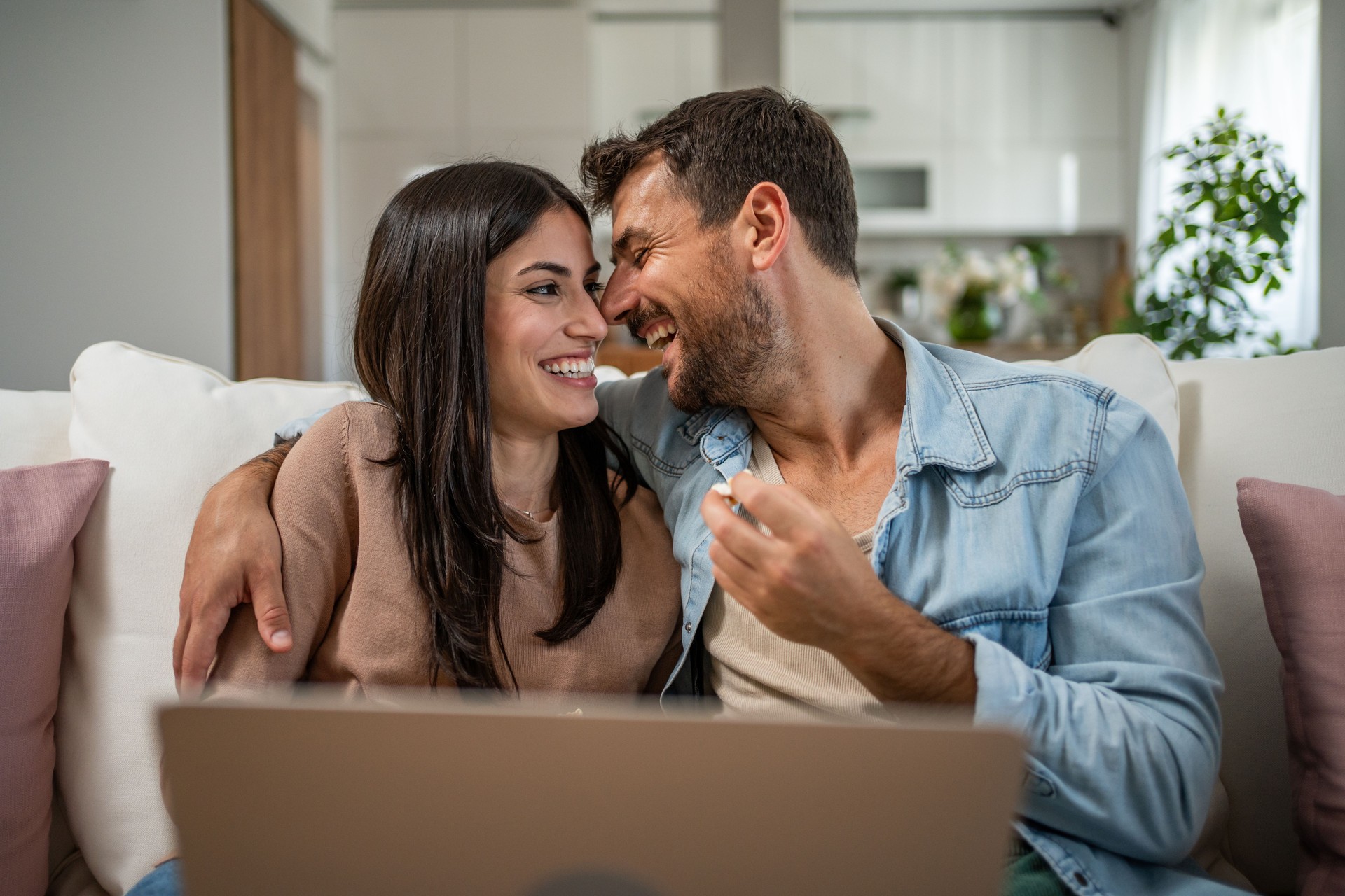 A daily dose of romance. Young couple enjoying a movie, popcorn and sofa confort.